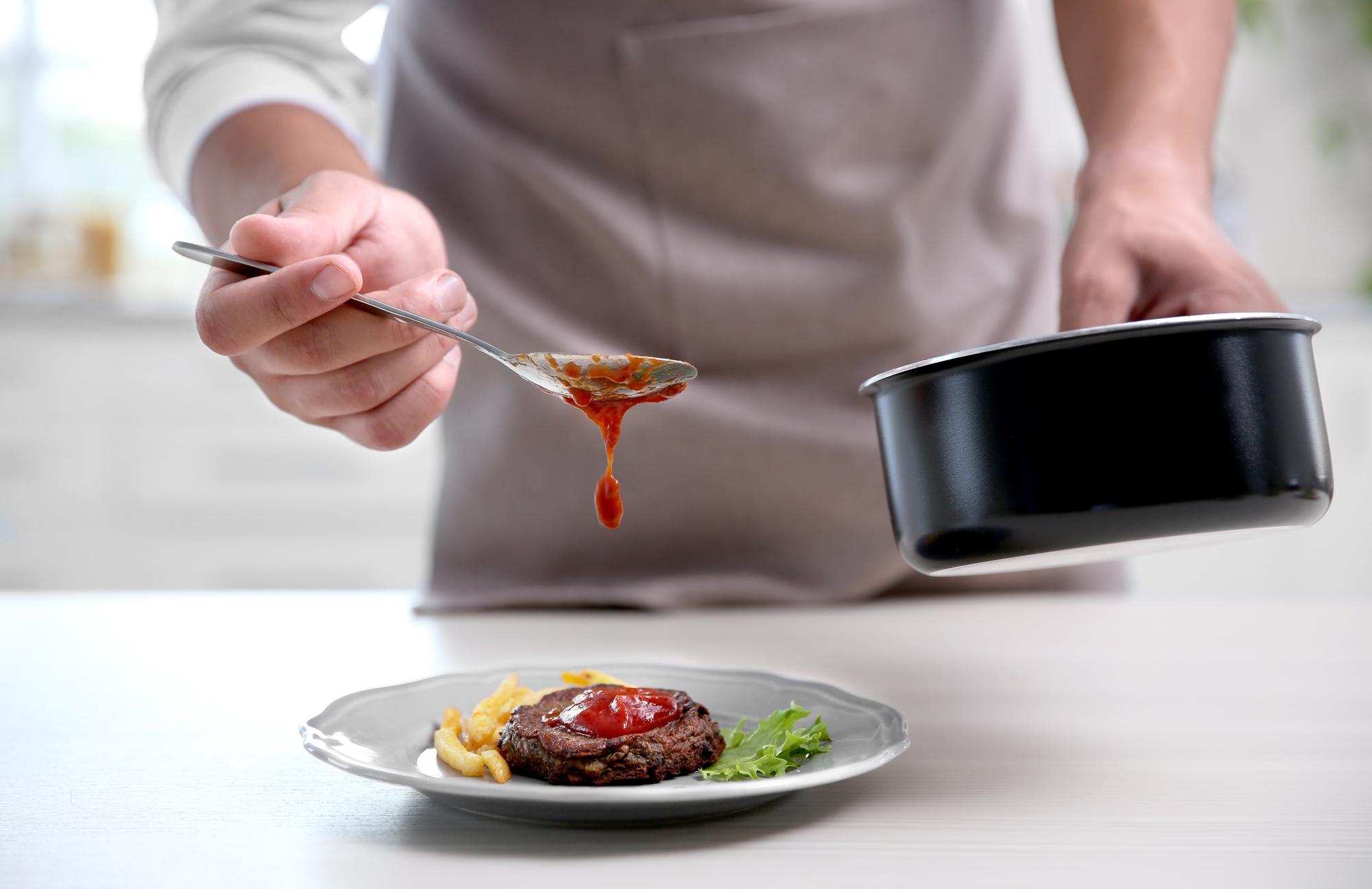 Chef testing sauce in jar